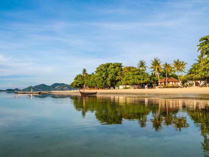 Travelers enjoying swimming and sunbathing on white sand under blue skies, highlighting the best time to visit Cam Ranh during the dry season.