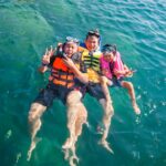 Thuyền thúng và tàu cá neo đậu trên mặt nước êm, phản ánh du lịch Cam Ranh mùa nào đẹp để khám phá văn hóa biển.